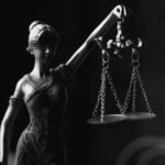 a grayscale of a lady justice figurine