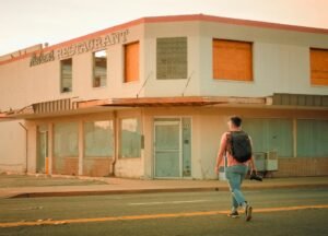 man with backpack crossing the road